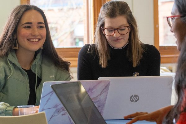 Three Sixth Form students studying on laptops
